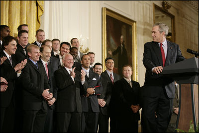 El Presidente George W. Bush mira a David Eckstein, seleccionado como el jugador más valioso, durante sus declaraciones en el homenaje del 16 de enero de 2007 en el East Room, a los St. Louis Cardinals, que ganaron el Campeonato de la Serie Mundial del 2006. Foto por Eric Draper de la Casa Blanca