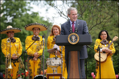 El Presidente George W. Bush les da la bienvenida a los invitados al Rose Garden en la Casa Blanca el viernes, 4 de mayo de 2007, para celebrar el Cinco de Mayo y reconocer las contribuciones de los méxico-americanos. Detrás se ven a miembros del grupo Los Hermanos Mora Arriaga, que tocaron música durante la ceremonia. Foto de Eric Draper de la Casa Blanca