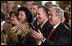 El Presidente George W. Bush aplaude al cantante Willy Chirino durante la celebración del Día de Solidaridad con Cuba, realizada en la Casa Blanca el 21 de mayo de 2008. Lo acompaña el ex preso político cubano Miguel Sigler Amaya, entre otros familiares y amigos de presos políticos cubanos.
