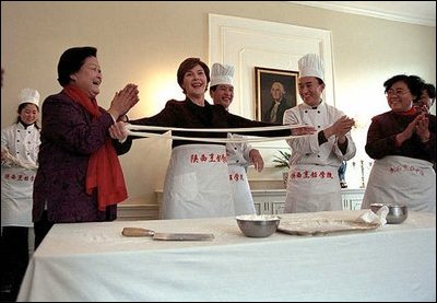 Mrs. Bush tries her hand at making fresh noodles during a Xian Culinary demonstration at the home of the U.S. Ambassador to China Thursday, February 21 2002 in Beijing. White House photo by Susan Sterner.