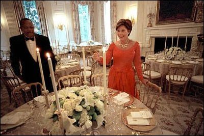 With just minutes to go before hosting her first State Dinner, Laura Bush lights the first candles of the Bush Administration's first State Dinner, September 5, 2001. White House photo by Eric Draper.