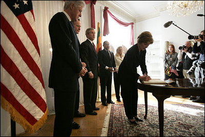 Laura Bush signs a condolence book for the victims of the recent tsunami during a visit to the Embassy of Sri Lanka in Washington, D.C., Monday, Jan. 3, 2005. Also signing to express their condolences are President George W. Bush and former Presidents Clinton and Bush. 