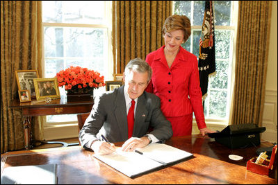 With Laura Bush looking on, President George W. Bush signs a proclamation designating February as American Heart Month in the Oval Office, Feb. 1, 2005. The proclamation encourages awareness of factors leading to heart disease such as smoking, high cholesterol, lack of exercise, obesity and diabetes.