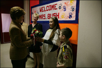 Hainerberg elementary students Montana Feix and Matt Bowlsby greet Laura Bush as she arrives to the school Tuesday, Feb. 22, 2005, in Wiesbaden, Germany. During her visit to the school Mrs. Bush heard a recital by the school chorus and talked with a group of fourth and fifth graders.