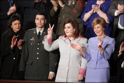 Safia Taleb al-Suhail, leader of the Iraqi Women's Political Council, second on right, displays a peace sign as other guests applaud during President George W. Bush's State of the Union speech at the U.S. Capitol, Wednesday, Feb. 2, 2005. Also pictured are, from left, Kindergarten teacher Lorna Clark of Santa Theresa, New Mexico, Army Staff Sergeant Norbert Lara, and Laura Bush.