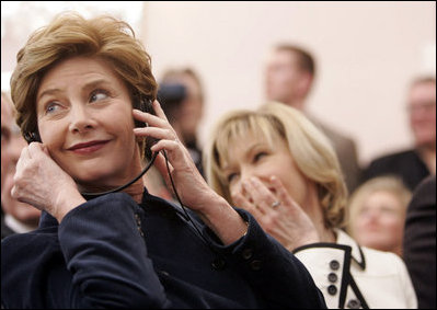 Laura Bush listens to translation headphones during a joint press conference with President George W. Bush and German Chancellor Gerhard Schroeder at the Electoral Palace in Mainz, Germany, Wednesday, Feb. 23, 2005. The Chancellor’s wife, Mrs. Schroeder-Koepf is seated next to Mrs. Bush.