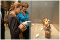 Elaine Karp de Toledo, First Lady of Peru, explains artifacts on display to Laura Bush during a visit to view the exhibit "Peru: Indigenous and Viceregal," at the National Geographic Society Friday, Feb. 25, 2005 in Washington, D.C. Also present is John Fahey, Jr., President and CEO of National Geographic Society.