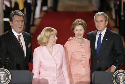 President George W. Bush and Ukraine President Viktor Yushchenko are joined at the podiums by first ladies Laura Bush and Kateryna Yushchenko Monday, April 4, 2005, in the East Room of the White House.