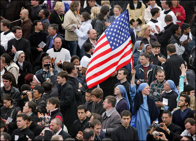 An American flag flies high above the throng of mourners inside St. Peter's square Friday, April 8, 2005, as thousands attend funeral mass for Pope John Paul II, who died April 2 at the age of 84.