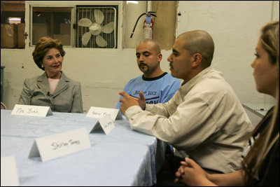 Laura Bush talks with, from left, Gabriel Flores, Archie Dominguez and Shirley Torres during a discussion at Homeboy Industries in Los Angeles April 27, 2005. Homeboys Industries is an job-training program that educates, trains and finds jobs for at-risk and gang-involved youth.