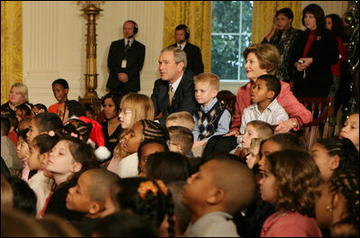 President George W. Bush and Laura Bush sit with children, Monday, Dec. 5, 2005 at the White House, as they watch a dance performance during the White House Children's Holiday Reception in the East Room.