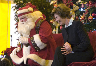 Laura Bush talks with children from New Orleans neighborhoods as she sits with Santa Claus, Monday Dec. 12, 2005 at the Celebration Church in Metairie, La., during a Toys for Tots event.