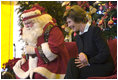 Laura Bush talks with children from New Orleans neighborhoods as she sits with Santa Claus, Monday Dec. 12, 2005 at the Celebration Church in Metairie, La., during a Toys for Tots event.