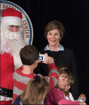 Laura Bush poses for a photo as she visits with children at the Naval and Marine Corps Reserve Center in Gulfport, Miss., Monday, Dec. 12, 2005, where she showed them a White House holiday video featuring the Bush's dogs "Barney and Miss Beazley."