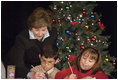 Laura Bush writes a note on a child's letter to his parent who is serving overseas, as she visits with children at the Naval and Marine Corps Reserve Center in Gulfport, Miss., Monday, Dec. 12, 2005, showing them a White House holiday video featuring the Bush's dogs "Barney and Miss Beazley."