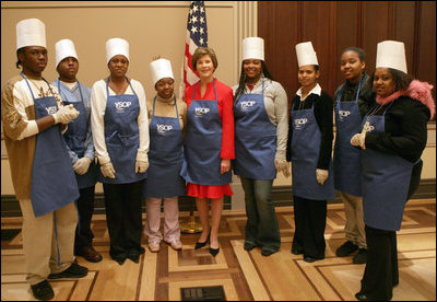 Mrs. Laura Bush and students at Cardozo Senior High School pose for pictures Monday, Dec. 19, 2005, in Washington, D.C. Mrs. Bush was on hand to join the Youth Services Opportunities Project in assembling sandwiches for Martha's Table's mobile soup kitchen.