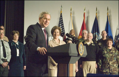 With Mrs. Laura Bush looking on, President George W. Bush addresses military medical caregivers Wednesday, Dec. 21, 2005, before visiting with the wounded at the National Naval Medical Center in Bethesda, Md. The President told the caregivers, "... On behalf of a grateful nation, thanks for doing your duty, thanks for serving, thanks for being an important part of this march for freedom; and thanks, most of all, for bringing comfort and aid and solace to those who have been hurt on the battlefield and their families."