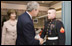 President George W. Bush shakes the hand of Marine Cpl. Andrew L. Tinsley of Annapolis, Md., Wednesday, Dec. 21, 2005, after Cpl Tinsley was presented the Purple Heart during a visit by the President and Laura Bush to the National Naval Medical Center in Bethesda, Md.