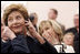 Laura Bush listens to translation headphones during a joint press conference with President George W. Bush and German Chancellor Gerhard Schroeder at the Electoral Palace in Mainz, Germany, Wednesday, Feb. 23, 2005. The Chancellor’s wife, Mrs. Schroeder-Koepf is seated next to Mrs. Bush.