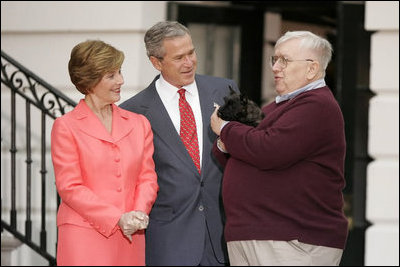 President George W. Bush and Laura Bush receive Miss Beazley, their new Scottish Terrier puppy, from breeder Bill Berry on the South Lawn of the White House Jan. 6, 2005. Miss Beazley is a birthday present from the President to Mrs. Bush. Beginning life at the White House in proper fashion, Miss Beazley's started her first day with a press conference.