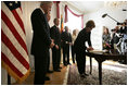 Laura Bush signs a condolence book for the victims of the recent tsunami during a visit to the Embassy of Sri Lanka in Washington, D.C., Monday, Jan. 3, 2005. Also signing to express their condolences are President George W. Bush and former Presidents Clinton and Bush.