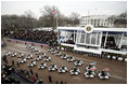 A procession of motorcycles leads the Inaugural Parade down Pennsylvania Avenue past the President's reviewing stand in front of the White House, Jan. 20, 2005. President George W. Bush and Laura Bush traveled with the parade after a swearing-in ceremony for the President at the U.S. Capitol.