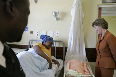 Laura Bush visits with a mother and her newborn baby while meeting with the group, "Mothers to Mothers-to-Be," in Cape Town, South Africa, Tuesday, July 12, 2005. The program provides support to HIV-positive women during their pregnancy.
