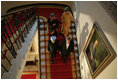President George W. Bush, Laura Bush and India's Prime Minister Dr. Manmohan Singh and Mrs. Gursharan Kaur walk down the stairs to the State Dining Room, Monday, July 18, 2005 at the White House, for the official dinner in honor of the visit by India's Prime Minister Dr. Manmohan Singh.