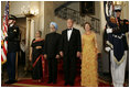 President George W. Bush, Laura Bush and India Prime Minister Dr. Manmohan Singh and Mrs. Gursharan Kaur, arrive for the official dinner in the State Dining Room at the White House Monday, July 18, 2005.