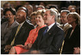 President George W. Bush, Laura Bush and HUD Secretary Alphonso Jackson, pictured at right, listen to performers during the White House reception honoring June as Black Music Month in the East Room Monday, June 6, 2005.