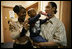 Kevion Thigpen, 3, held by his parents Kanyatta "Ken" Thigpen and his girlfriend Jewell Reed plays with a kaleidescope given to him by Laura Bush during a visit to the Rosalie Manor Community and Family Services center in Milwaukee, Wis., Tuesday, March 8, 2005. Citing a New York Times article by Jason DeParle Mrs. Bush credits Mr. Thigpen's determination to be a responsible father with bringing her attention to the needs of boys and young men.