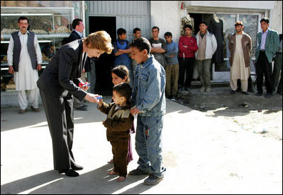 Laura Bush is greeted by youngsters outside a Kabul bakery during her visit Wednesday, March 30, 2005. The first lady presented White House red, white & blue kaleidoscopes to the children.