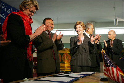Laura Bush applauds as Secretary of Education Margaret Spellings and Afghan Minister of Education Noor Mohammas Qarqeen complete the signing of the Memorandum of Understanding for funds to build a university in Kabul, Afghanistan Wednesday, March 30, 2005.