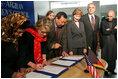 Laura Bush observes as Secretary of Education Margaret Spellings and Afghan Minister of Education Noor Mohammas Qarqeen complete the signing of the Memorandum of Understanding for funds to build a university in Kabul, Afghanistan Wednesday, March 30, 2005.