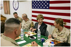 Laura Bush laughs with troops as they eat dinner in the Dragon Chow Dining Hall on Bagram Air Base in Kabul, Afghanistan Wednesday, March 30, 2005.
