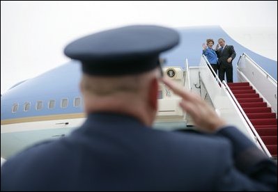 President George W. Bush returns a salute from Brigadier General David S. Gray, Commander, 89th Airlift Wing as he and Mrs Bush board Air Force One before departing Andrews Air Force Base for Latvia, Friday, May 6, 2005.