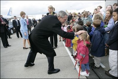 Greeted by flowers and smiles, President George W. Bush returns the gesture during his and Laura Bush's arrival in Maastricht, Netherlands, May 7, 2005.