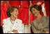 Laura Bush and former First Lady Nancy Reagan share a moment Thursday, May 12, 2005, at the John F. Kennedy Center for the Performing Arts during the unveiling of The Heart Truth’s First Ladies Red Dress Collection.