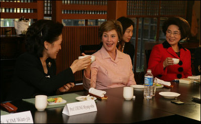 Mrs. Bush tips her teacup to Professor Chung Myung-wha during a discussion Saturday, Nov. 19, 2005, with women leaders in Busan, Korea.