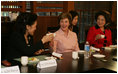 Mrs. Bush tips her teacup to Professor Chung Myung-wha during a discussion Saturday, Nov. 19, 2005, with women leaders in Busan, Korea.