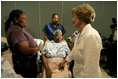 Laura Bush reaches out to a victim of Hurricane Katrina during a visit Friday, Sept. 2, 2005, to the Cajundome at the University of Louisiana in Lafayette. "The people of this part of the United States, the Lafayette area of Louisiana, are very, very warm people," said Mrs. Bush. "They've opened their hearts, and many of them have opened their homes, as well, to people from New Orleans -- family members and strangers."