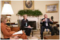 President George W. Bush, seen with U.S. Secretary of Education Margaret Spellings, center, and Laura Bush, left, gestures as he speaks with reporters, Tuesday, Sept. 6, 2005 in the Oval Office at the White House, about efforts the Department of Education is undertaking with a program, "Hurricane Help for Schools," established to assist schools and students affected by Hurricane Katrina.