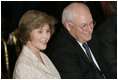 Laura Bush and Vice President Dick Cheney sit together, Thursday, Sept. 29, 2005, during the swearing-in ceremony for John G. Roberts, Jr., Chief Justice of the United States Supreme Court, in the East Room of the White House.