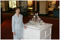 Mrs. Laura Bush poses for a photo next to the State Egg Display which exhibits a decorated egg from a select artist of each state Thursday, April 6, 2006, at the White House Visitor Center. This tradition has been going on since 1994, and each year the artists vote amongst themselves to select the artist to create the following year's commemorative egg which is presented to the President and First Lady.