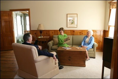 Mrs. Laura Bush, Mrs. Barbara Bush, and former President George H.W. Bush share a moment in the living room of President George W. Bush's Childhood Home in Midland, Texas, on Tuesday, April 11, 2006, prior to a dedication and ribbon cutting ceremony of the home.