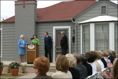 Mrs. Laura Bush, joined by former President George H.W. Bush, Mrs. Barbara Bush, and family friend, Joe O'Neill, speaks to the crowd on Tuesday, April 11, 2006, during a dedication and ribbon cutting ceremony for the opening of President George W. Bush’s Childhood Home in Midland, Texas.