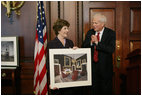 Mrs. Laura Bush is presented with a print by Dr. James Billington, the Librarian of Congress, showing an interior view of the White House as it looked in the early 1900s, Wednesday, April 26, 2006 during the James Madison Council Luncheon at the Library of Congress.