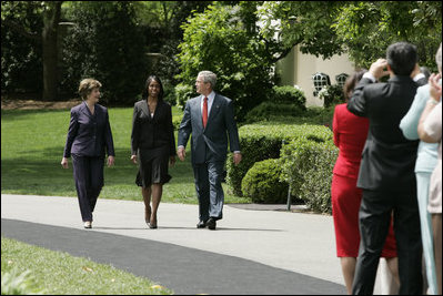 President George W. Bush and Mrs. Laura Bush accompany 2006 National Teacher of the Year Kim Oliver to the South Lawn ceremony in her honor Wednesday, April 26, 2006. Said the President of the Silver Spring, Maryland kindergarten teacher, "Kim Oliver understands that the key to helping children succeed is fighting the soft bigotry of low expectations."