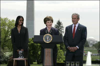 Mrs. Laura Bush addresses the audience Wednesday, April 26, 2006, as President Bush and Kim Oliver, the 2006 National Teacher of the Year, look on during a ceremony on the South Lawn honoring Ms. Oliver and the State Teachers of the Year.