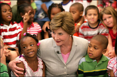 Mrs. Laura Bush embraces two students Monday, Aug. 28, 2006, as she meets and speaks with members of the Gorenflo Elementary School first grade class in their temporary portable classroom at the Beauvoir Elementary School in Biloxi, Miss. The students, whose school was damaged by Hurricane Katrina, are sharing the facilities of the Beauvoir school until their school’s renovations are complete.